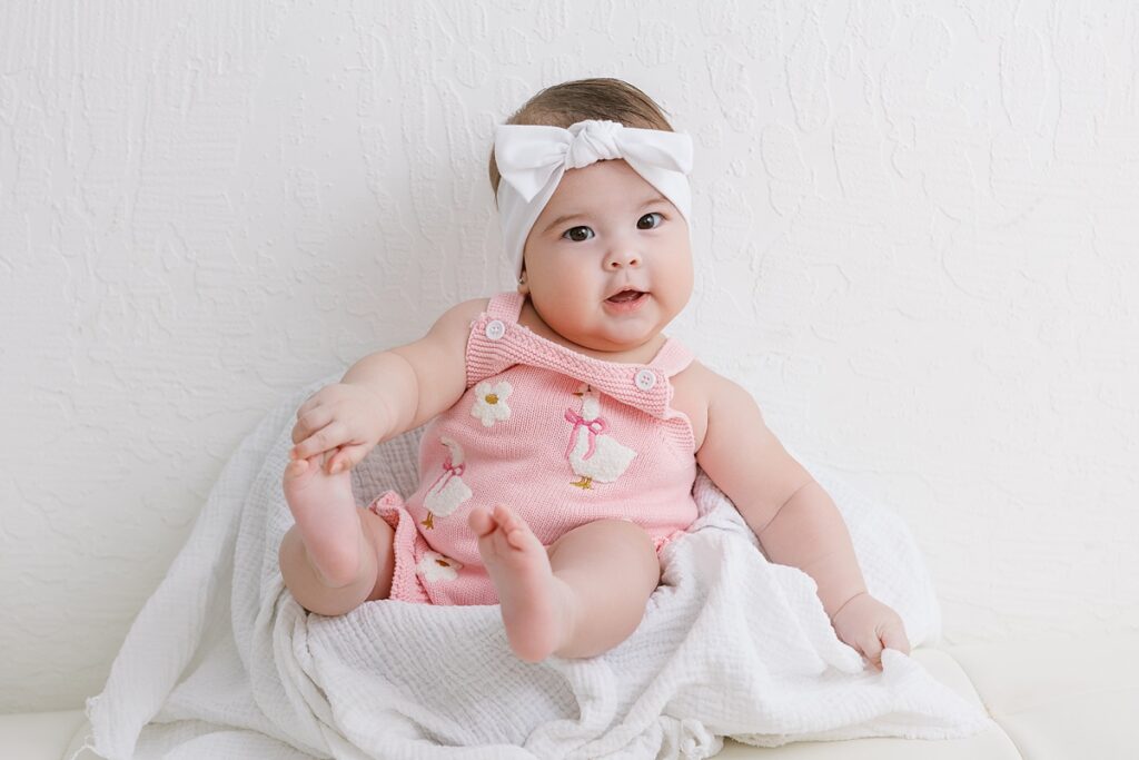 6 month old baby girl holding her toes in mesa az photo studio
