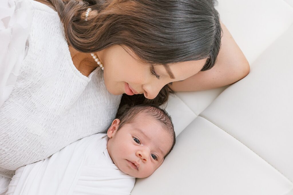 mom laying next to her newborn son cuddled up together in scottsdale arizona photo studio