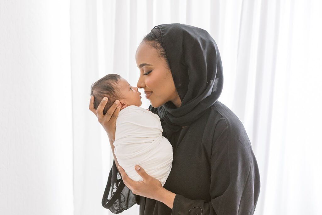 mom wearing hijab gazing at her newborn baby boy in scottsdale studio