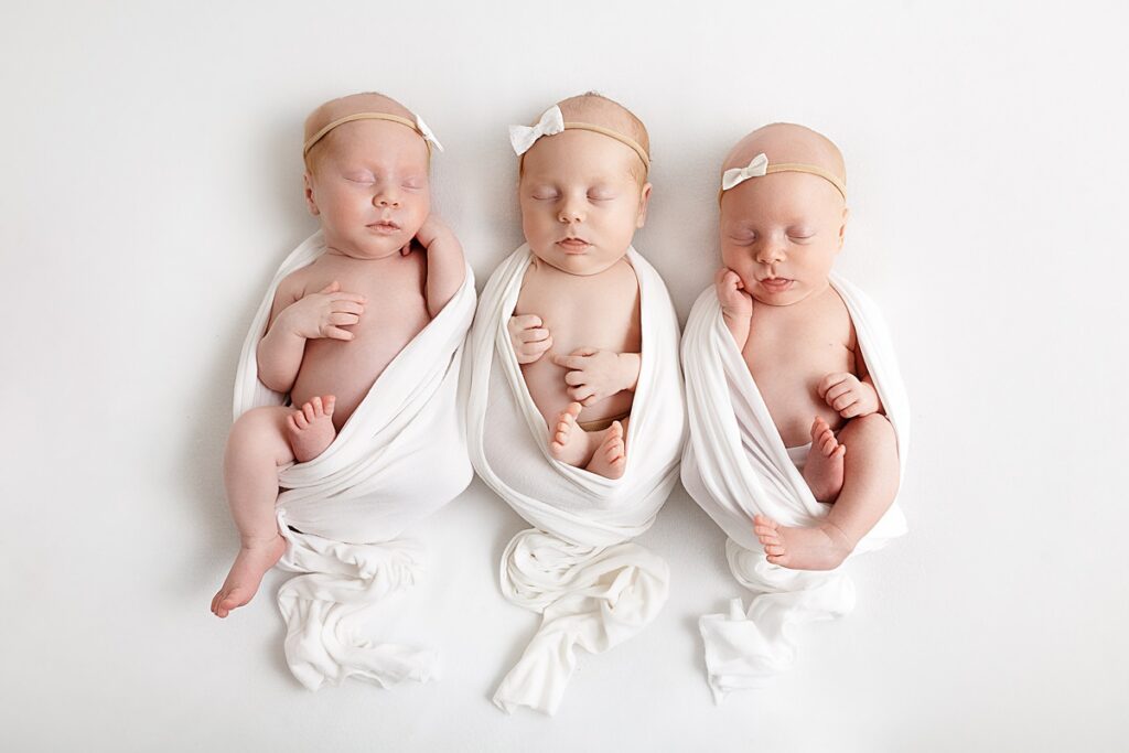 triplet newborns in white swaddles in phoenix arizona studio