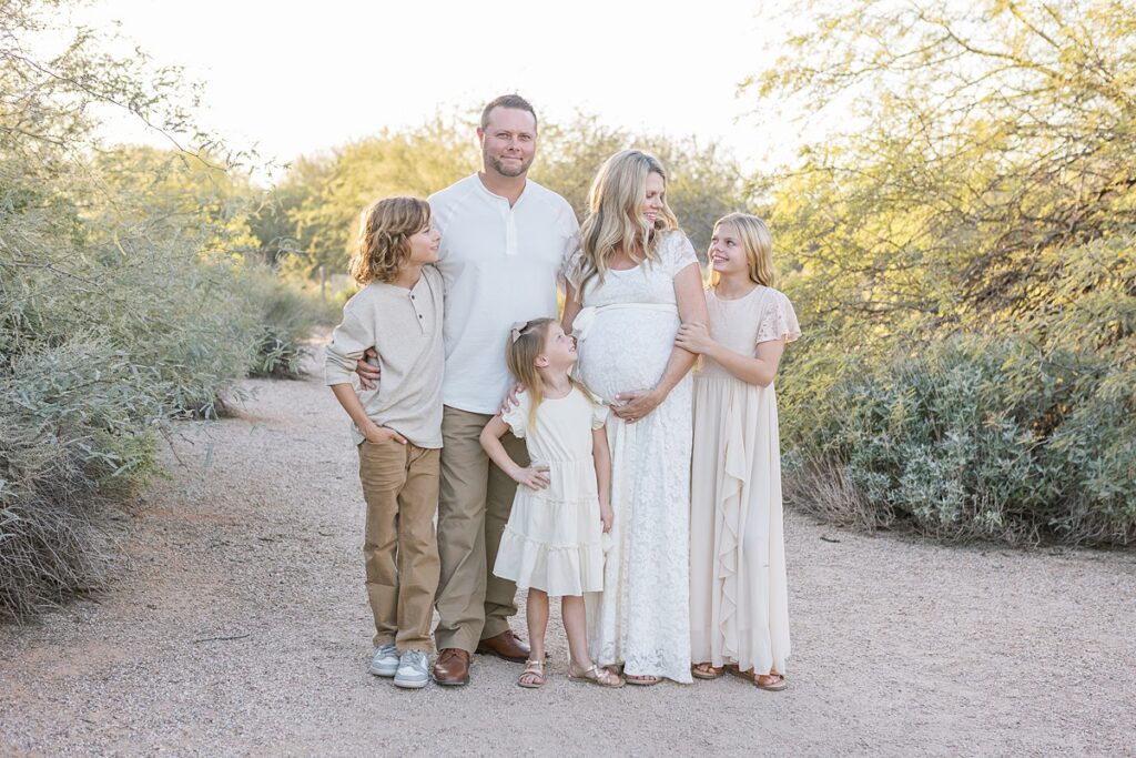 Family of 5 looking at each other in phoenix maternity photoshoot at the riparian preserve