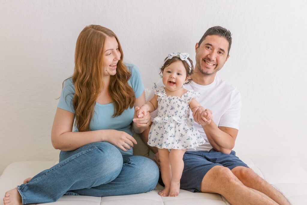 Six-month-old baby with her parents during a family milestone photography session