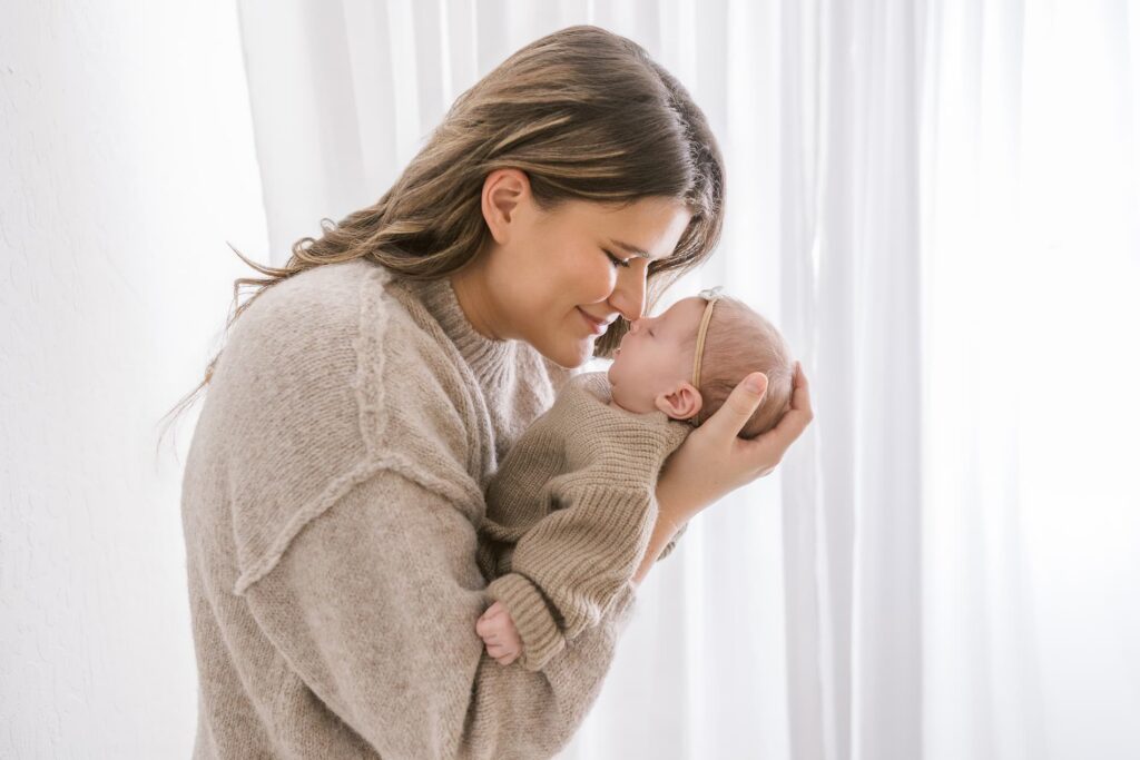 Mom holding her newborn baby during a family newborn photography session