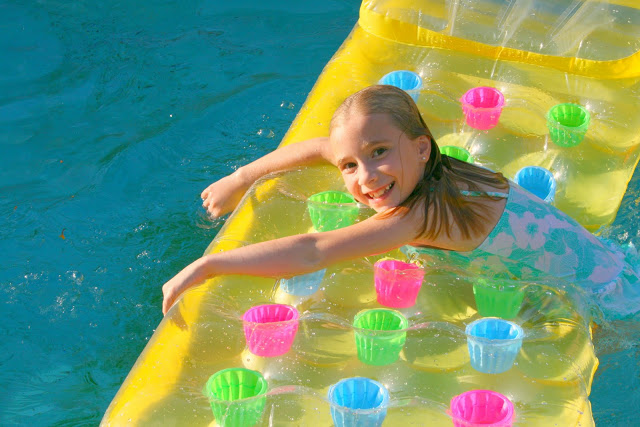little girl floating on a raft in a pool