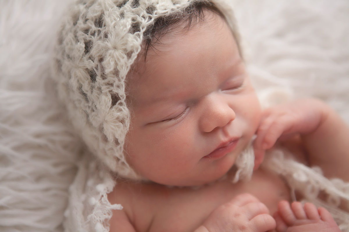 newborn baby girl wearing knit bonnet 