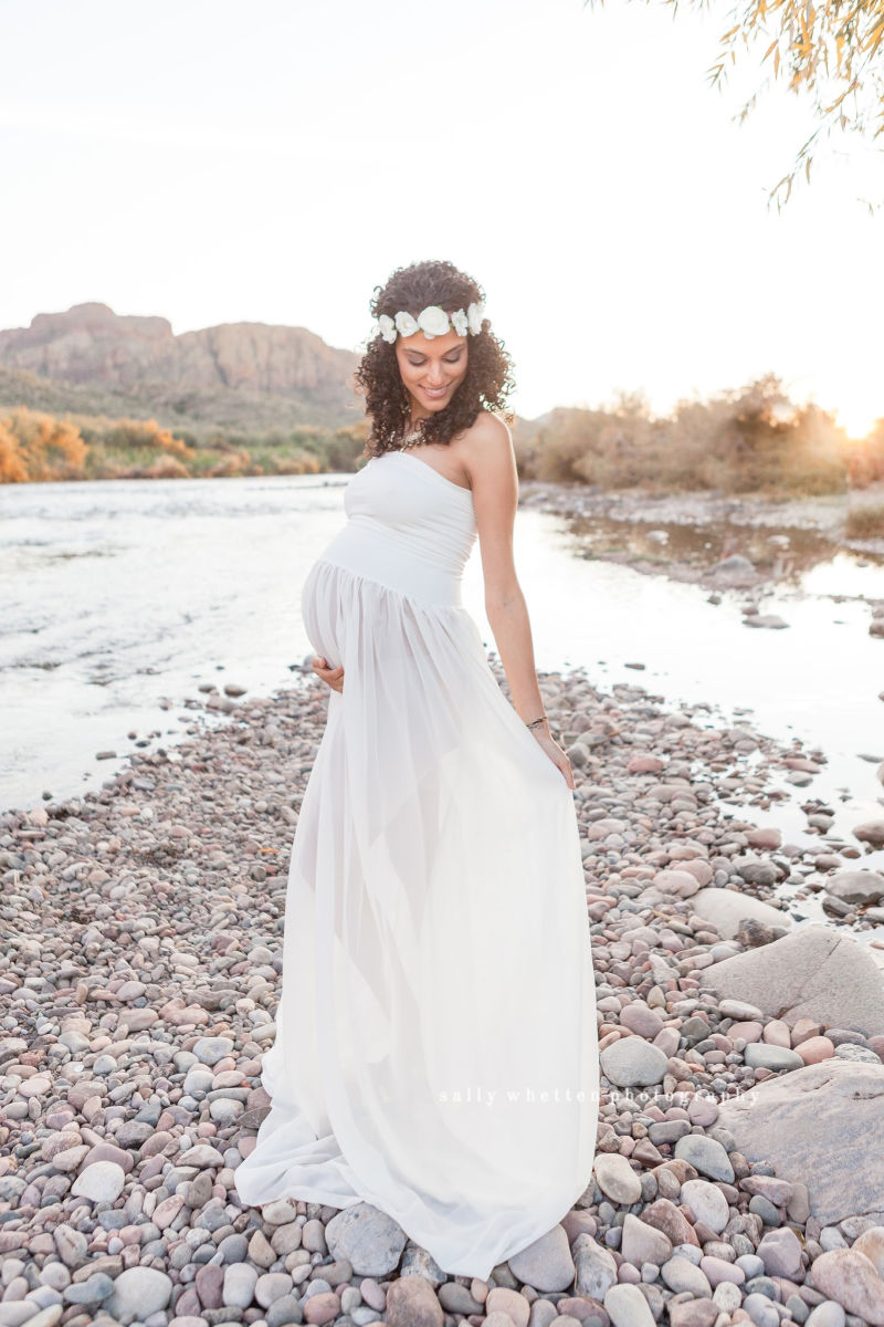 gorgeous pregnant woman in white dress by the river