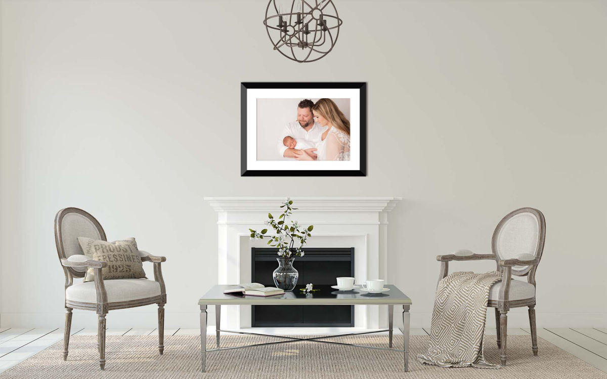 large framed newborn family photo above mantle