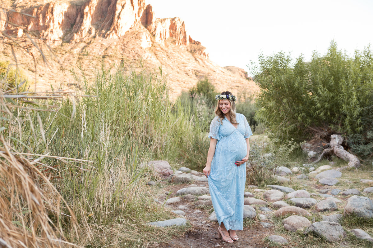 expecting mother in blue lace dress by the salt river for a maternity photo session