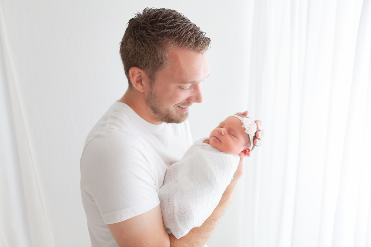 East Mesa Baby Photographer, Dad in a white shirt holding baby girl in a white swaddle