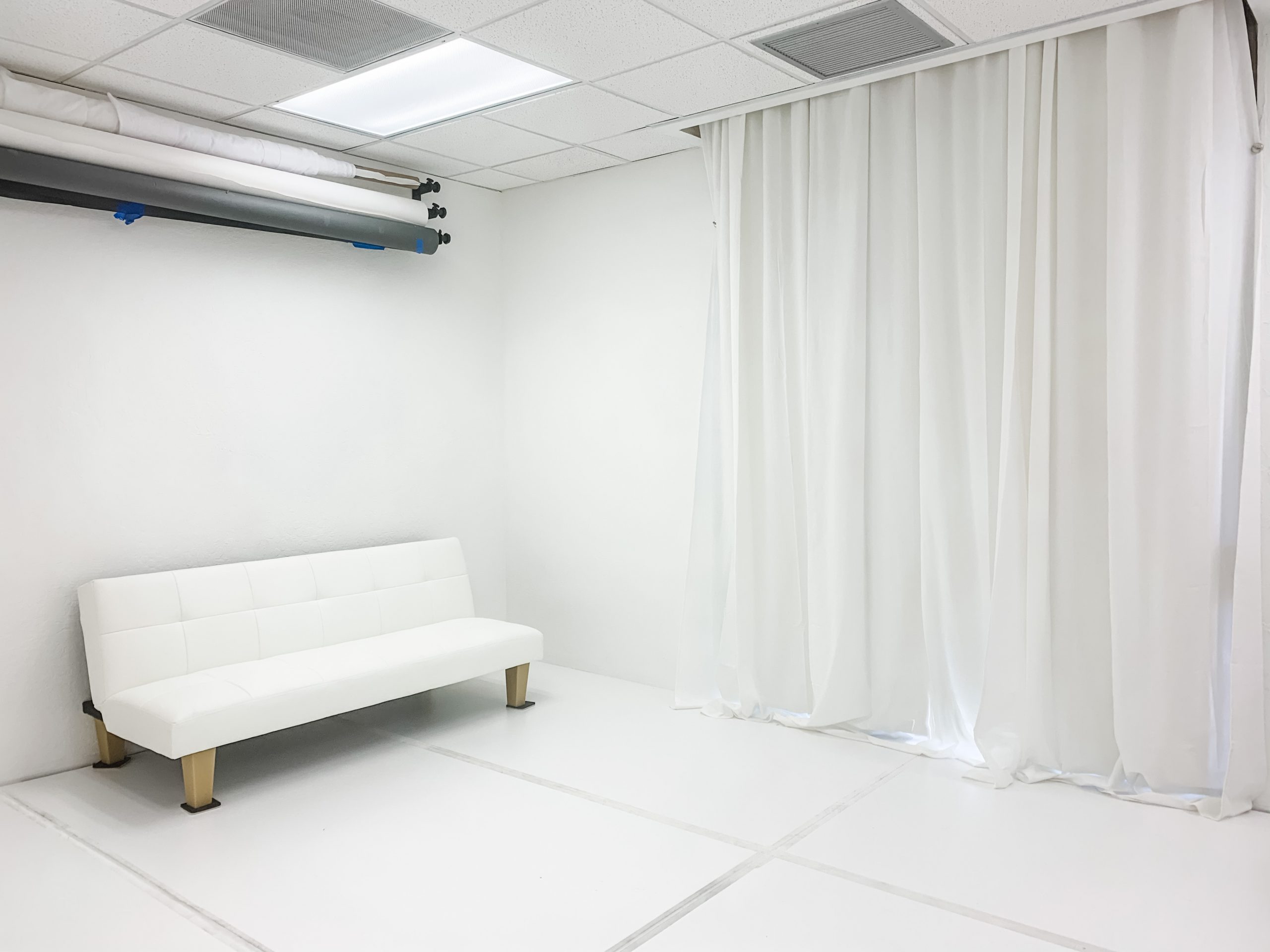 white futon and white curtains in newborn and maternity studio