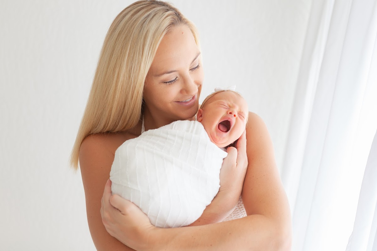 Phoenix Baby Photographer by Sally Whetten Photography mother holding newborn baby giving a big yawn