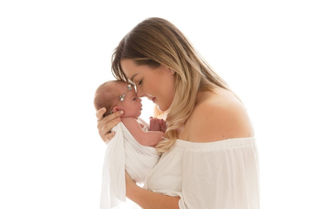 New mom gently nuzzling her newborn’s forehead during a Scottsdale newborn session with mom