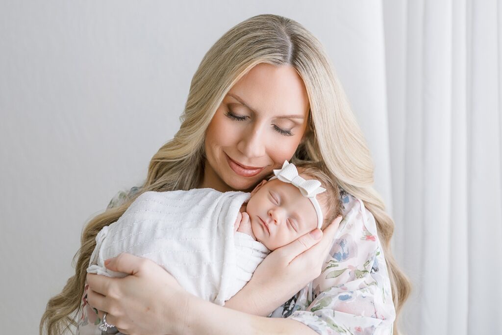 Close-up of a mother’s gentle expression as she cuddles her newborn
