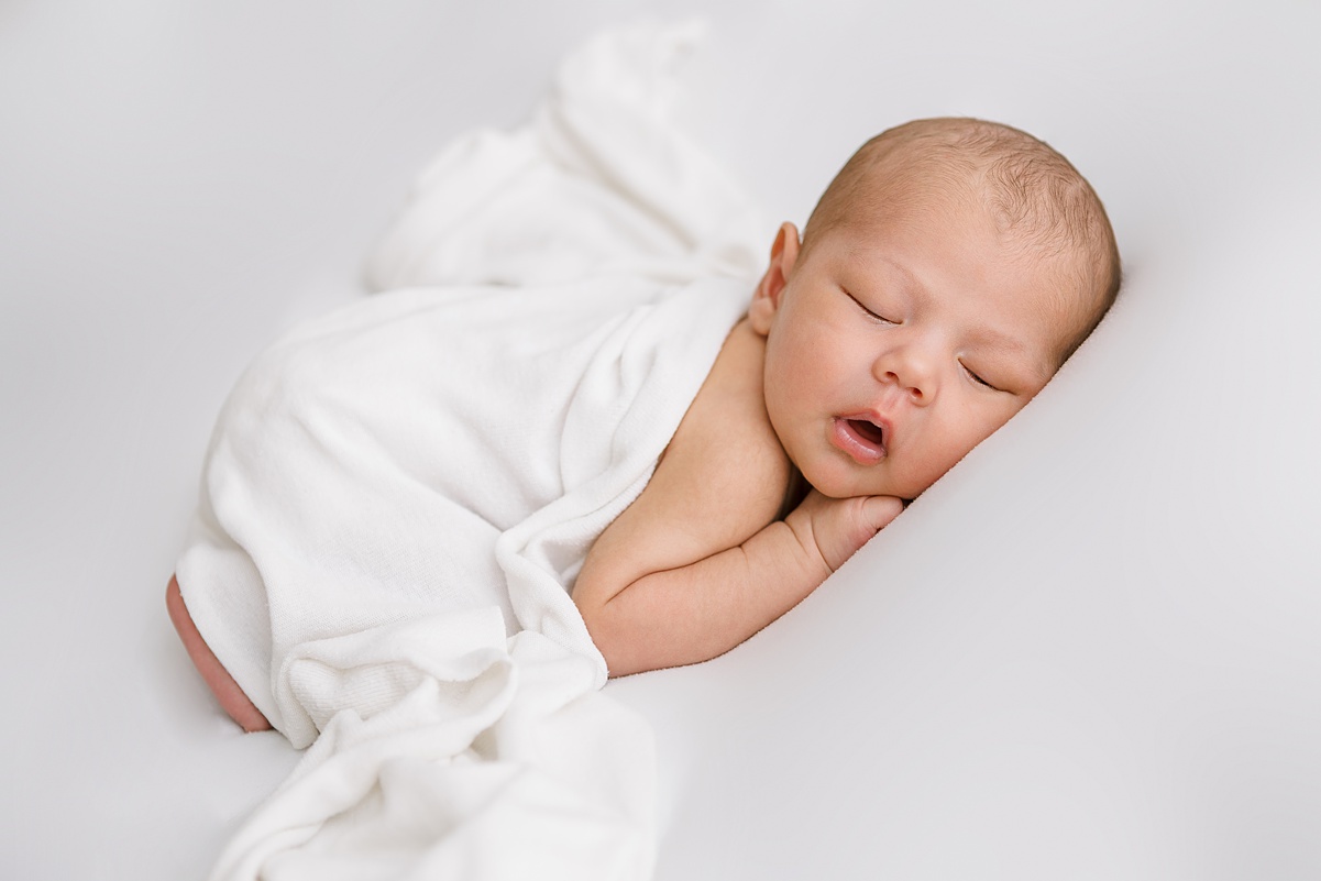 Soft and minimalist newborn portrait using white backdrop and soft light
