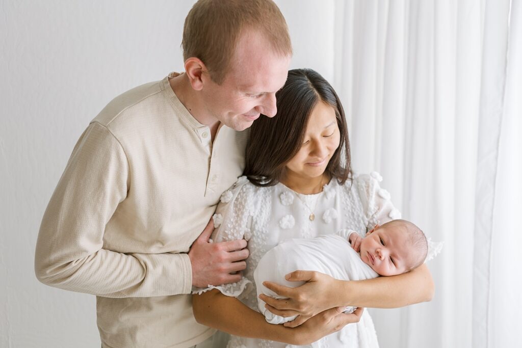 Natural newborn and parent portrait in neutral colors, showcasing emotional connection