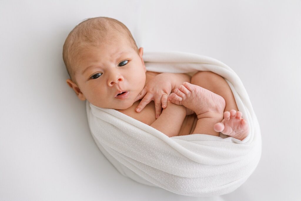 Soft and minimalist newborn portrait using white backdrop and soft light