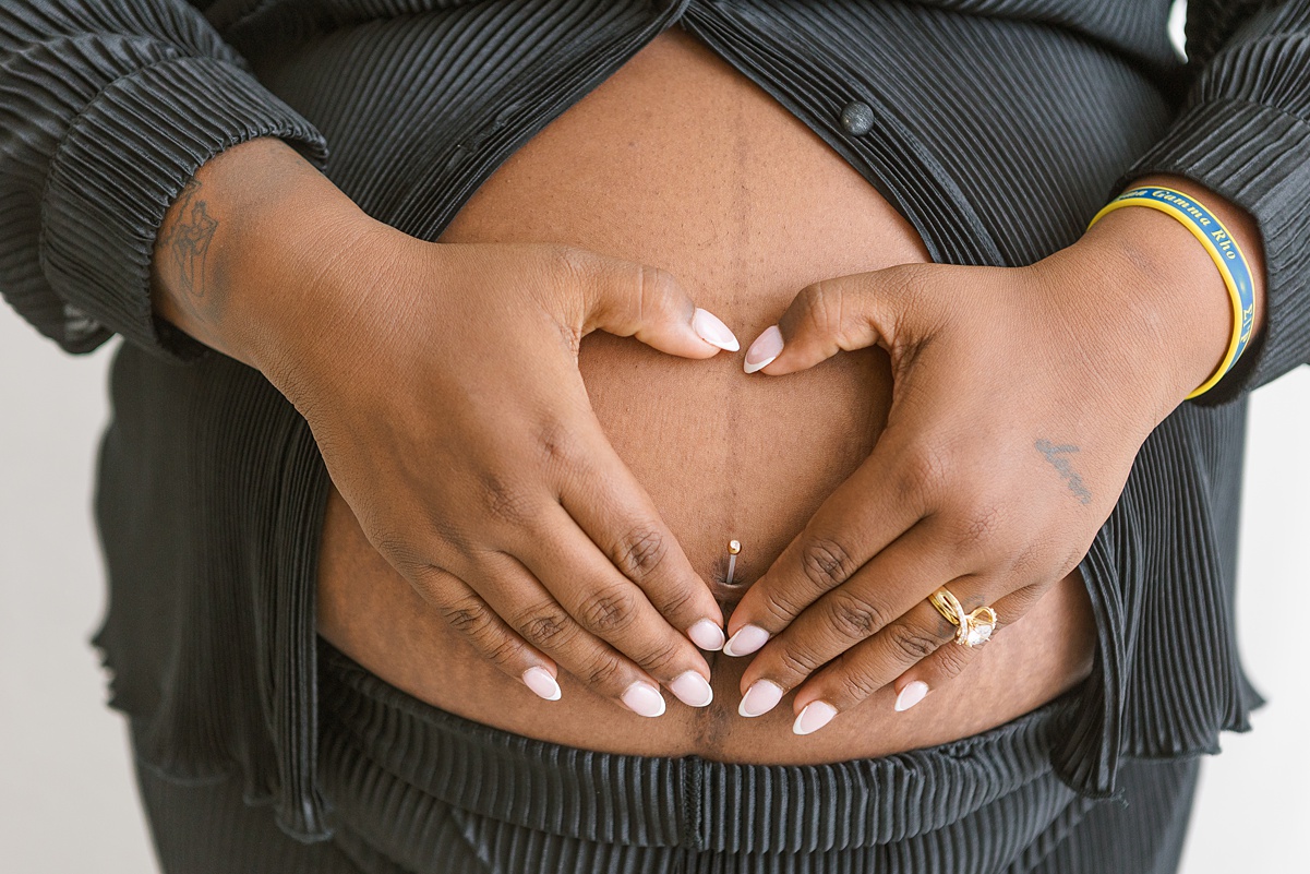 hands in heart shape on pregnant belly in mesa arizona photo studio